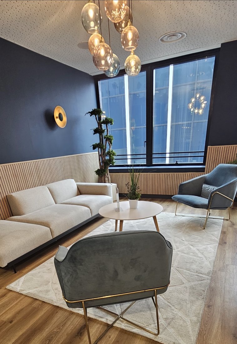 Espace d'accueil de bureaux aménagé par Rivage Transport : canapé, deux fauteuils et tapis